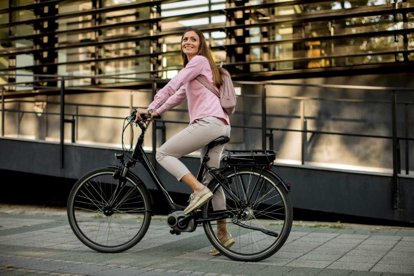 Eine junge Frau fährt auf ihrem E-Bike.