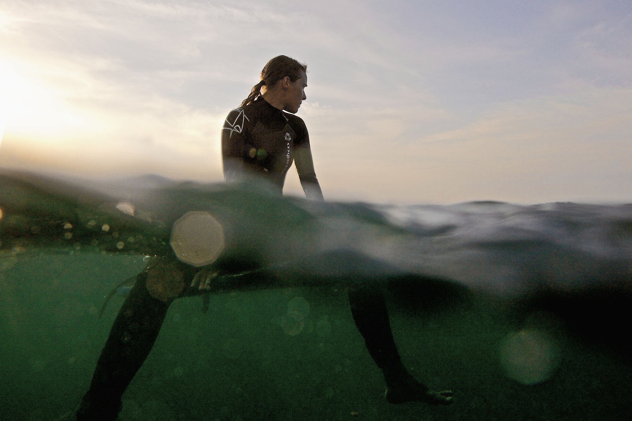Surferin im Wasser auf einem Surfbrett sitzend