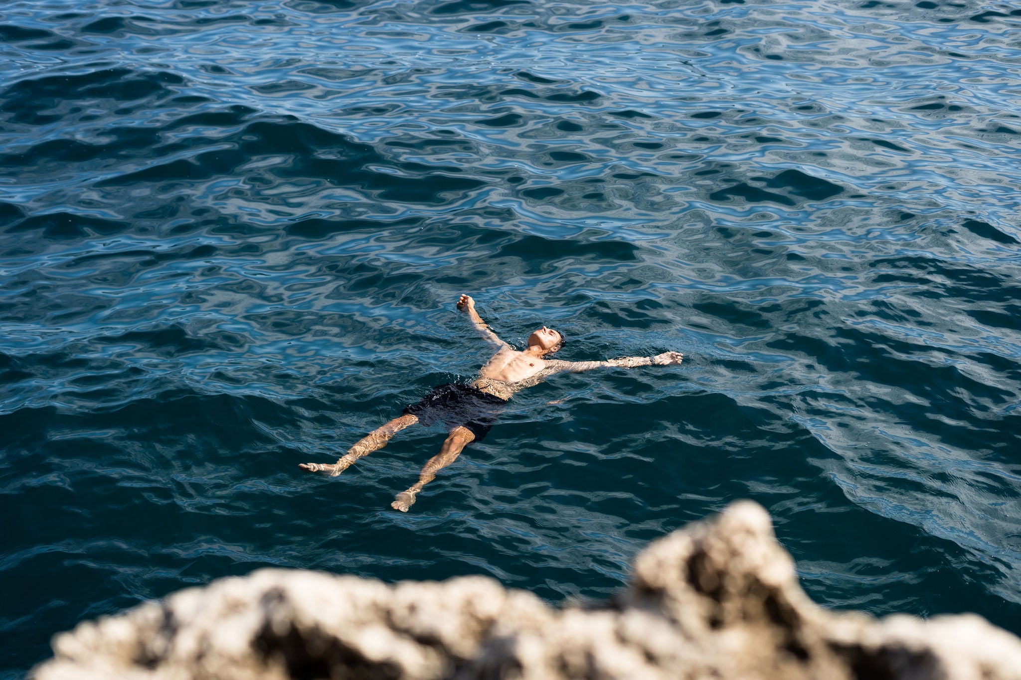 Ein junger Mann treibt entspannt im Meer