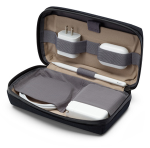 Bellroy Travel Organizer, Reißverschluss offen und aufgeklappt, mit vier elastischen Halterungen, die ein kleines Netzteil, ein AirPods Case, ein Kabel und ein großes Netzteil halten