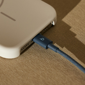 Gewebtes Beats USB-C auf USB-C Kabel in Turbo-Blau, das mit einem Apple iPhone verbunden ist.
