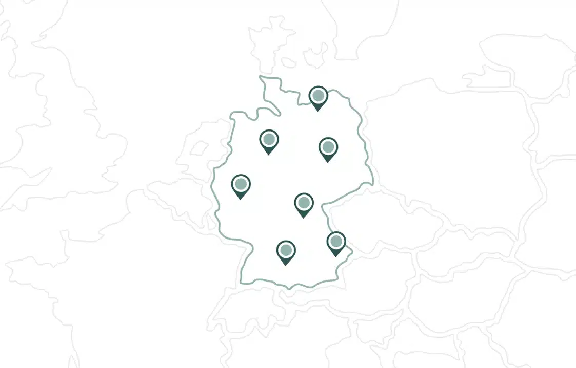 Übersichtskarte Von Deutschland Mit Sieben Stecknadeln, Die Verschiedene Orte Innerhalb Des Landes Markieren; Die Umliegenden Länder Sind Nur Schwach Sichtbar.